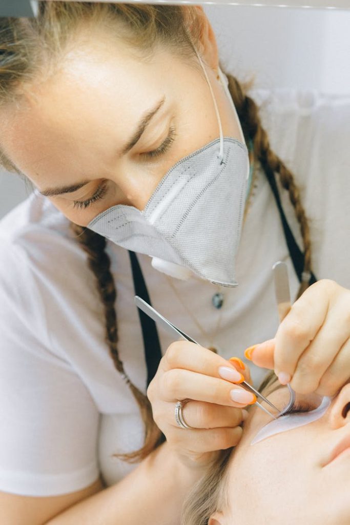 A skilled technician applying eyelash extensions with precision.